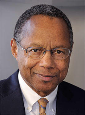 Dr. A. Eugene Washington wearing a blue suit jacket, white shirt and gold tie. 